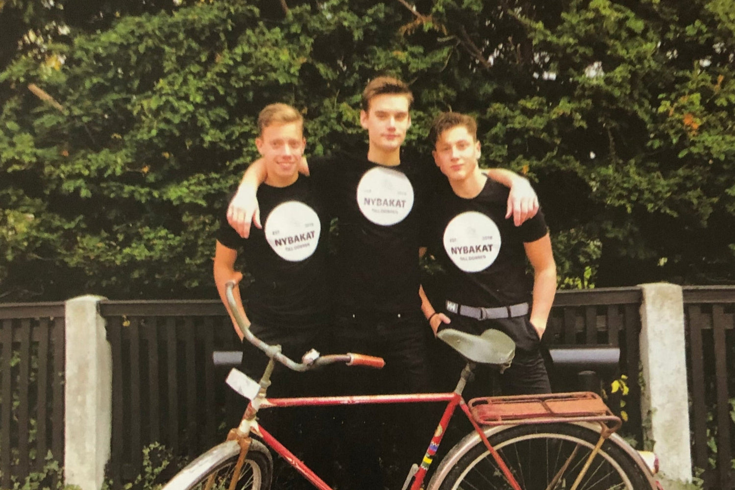 Tre ungdomar med cykel och Nybakat-tröjor